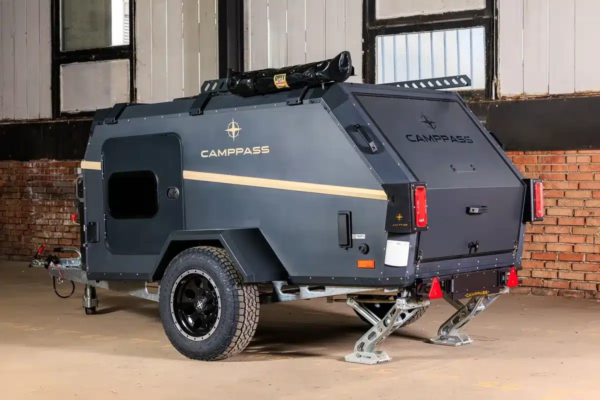 Seiten- und Rückansicht des kompakten Camppass CR400 Campinganhängers in einer Halle.