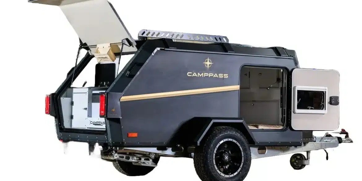 Camppass CR400 Campinganhänger mit geöffneter Seitentür und Klappe, Ansicht von hinten rechts.