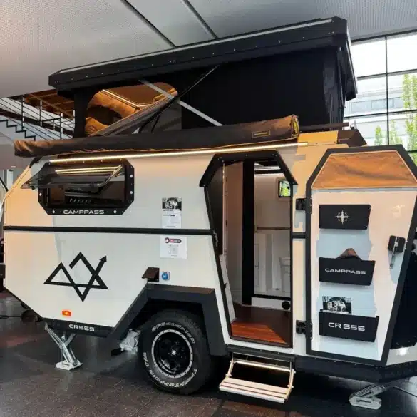 Camppass CR555 Offroad-Camper mit aufgeklapptem Dach und geöffneter Tür, Innenraum teilweise sichtbar.