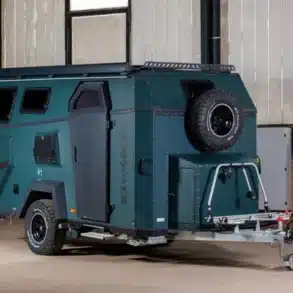 Camppass CR650 Caravan mit Ersatzrad, markanter Lackierung und robustem Fahrgestell in einer Halle