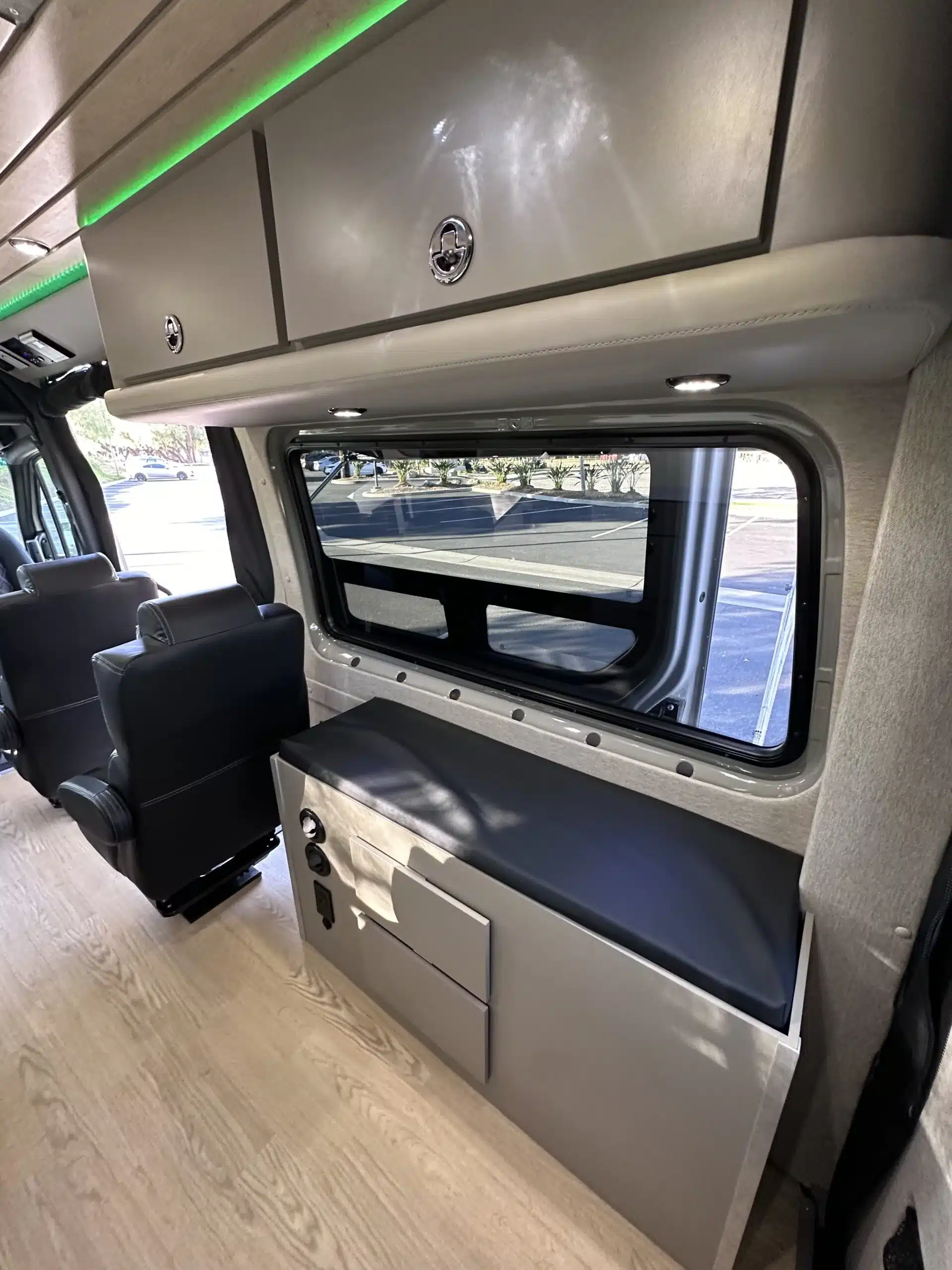 Moderner Van-Innenraum des Carpool Cruiser mit Premium-Sitzen, Bordküche, Stauschränken und Fenster.