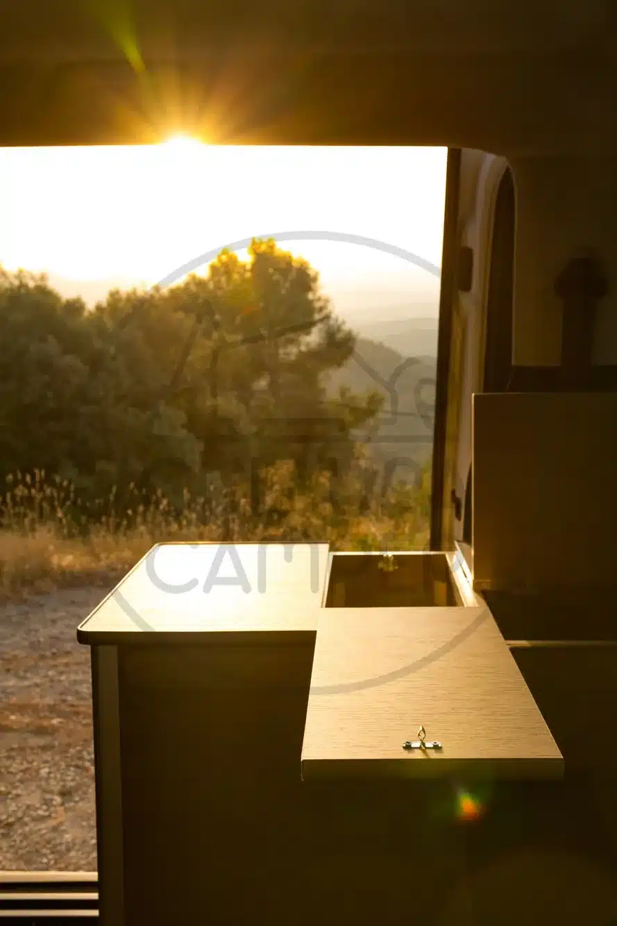 Maßgefertigte Camper-Möbel im Citroën SpaceTourer, fotografiert bei Sonnenaufgang mit Blick ins Grüne