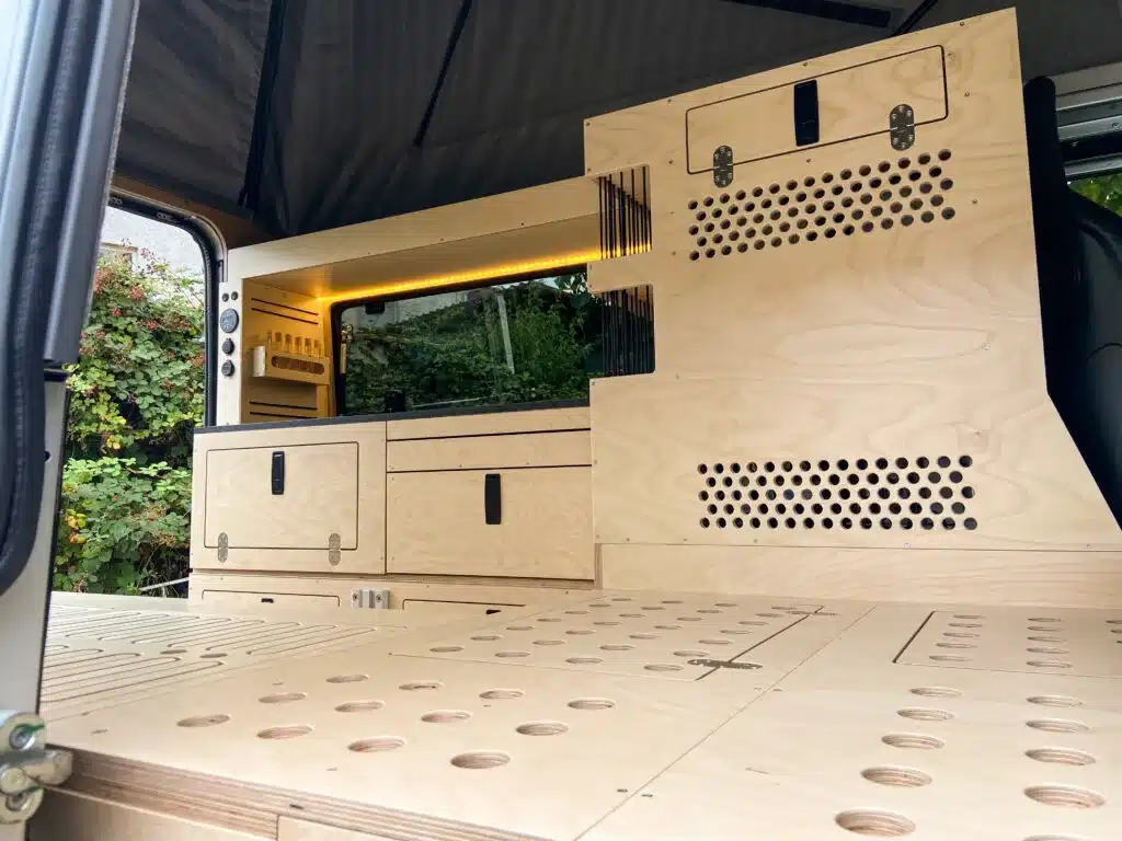 Camper-Ausbau im Land Rover Defender mit Holzinnenausbau, Stauraum und L-förmigem Grundriss