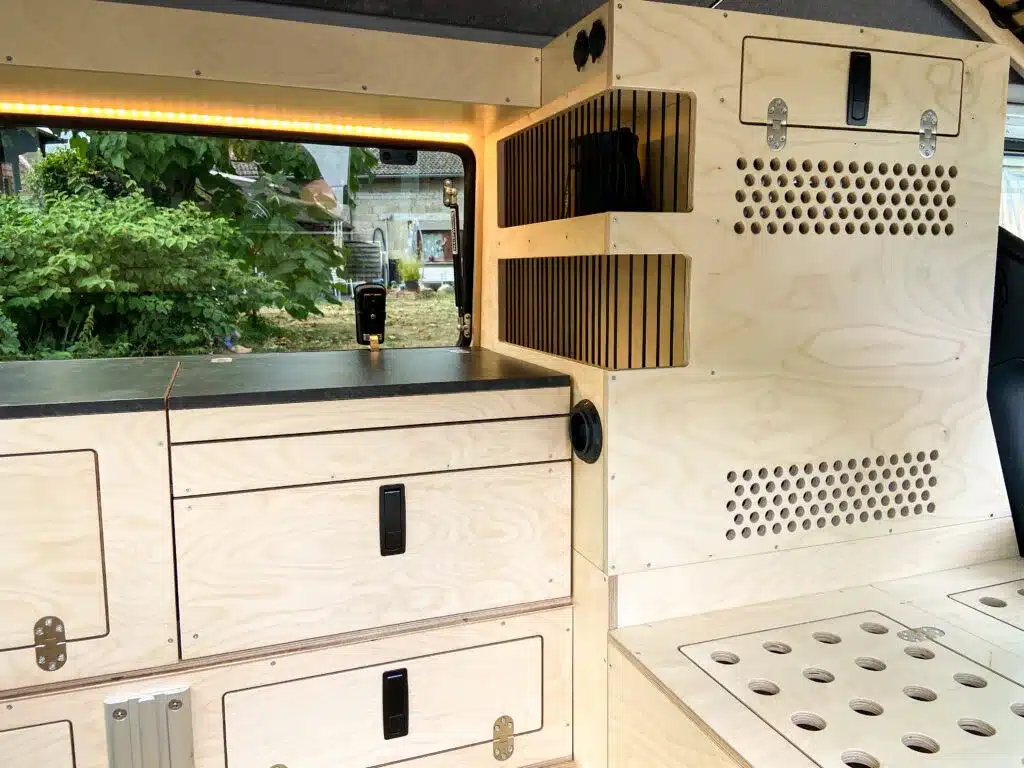 Der Innenausbau eines Land Rover Defender 110 als Camper mit maßgefertigten Holzmodulen, Stauflächen und Belüftungsschlitzen