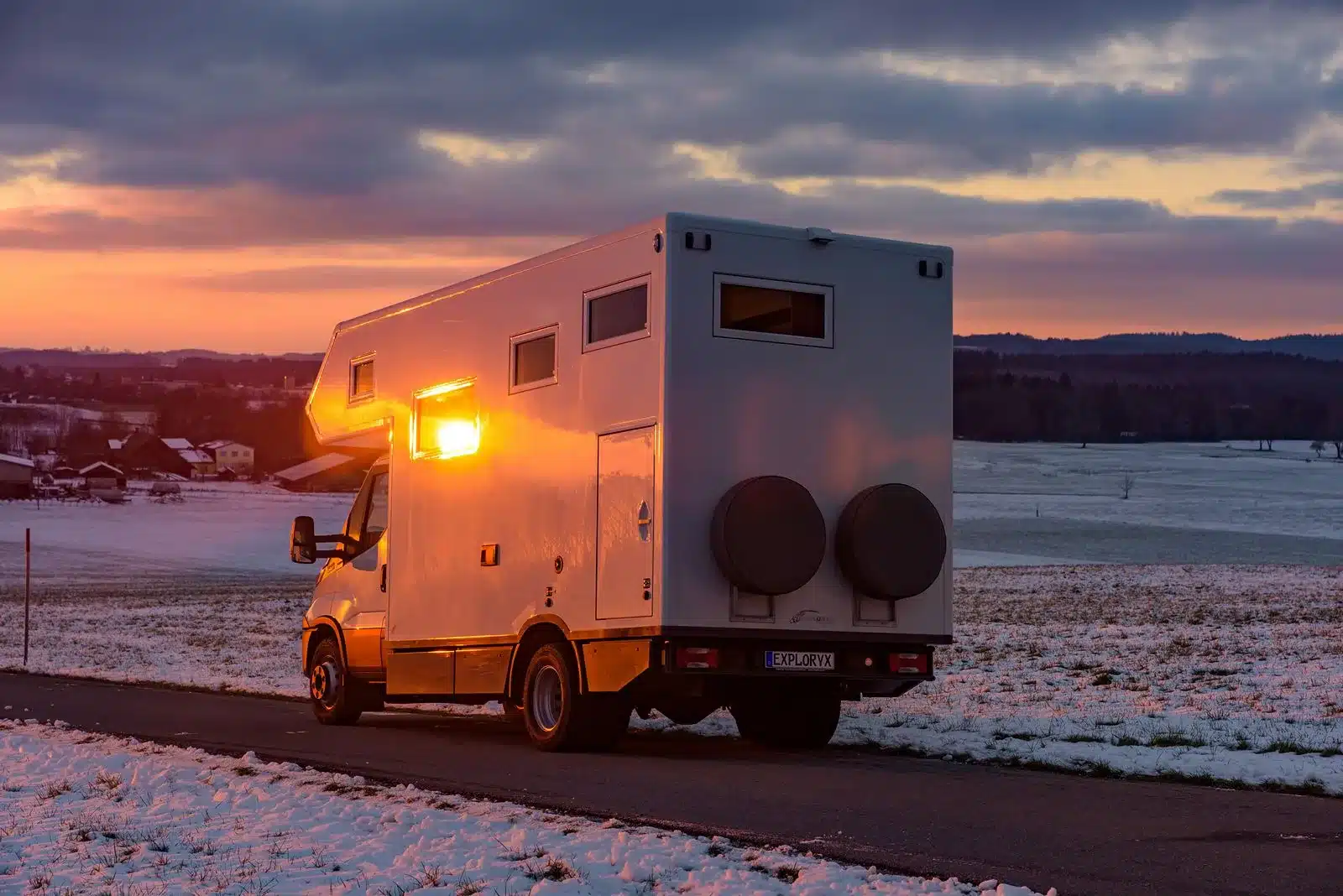 Exploryx Eland Expeditionsfahrzeug auf Basis des Iveco Daily in winterlicher Landschaft bei Sonnenuntergang.