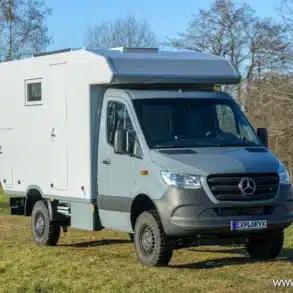 Exploryx Impala XV Expeditionsfahrzeug auf Mercedes-Benz Sprinter 416 CDI 4x4, aufgenommen auf einer Wiese, Ansicht von vorne schräg rechts.