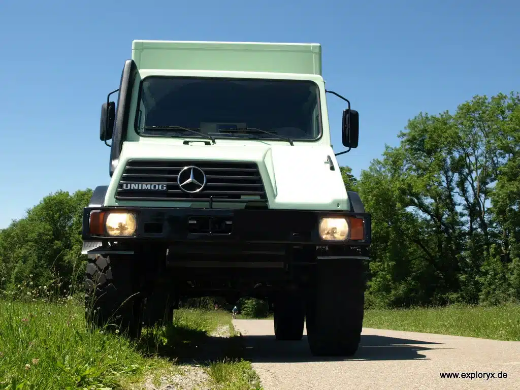 Exploryx Klippspringer U140L Expeditionsmobil auf Mercedes-Benz Unimog, mintgrün, frontal fotografiert auf einer Landstraße