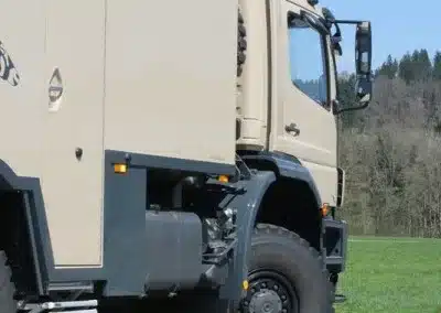 Exploryx Nyala Axor Expeditionsmobil auf einer Wiese, Seitenansicht Fahrerhaus und Wohnkabine
