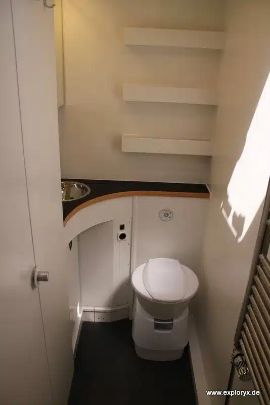 Innenansicht eines kompakten Badezimmers mit Toilette und Waschtisch im Expeditionsfahrzeug Exploryx Nyala Axor