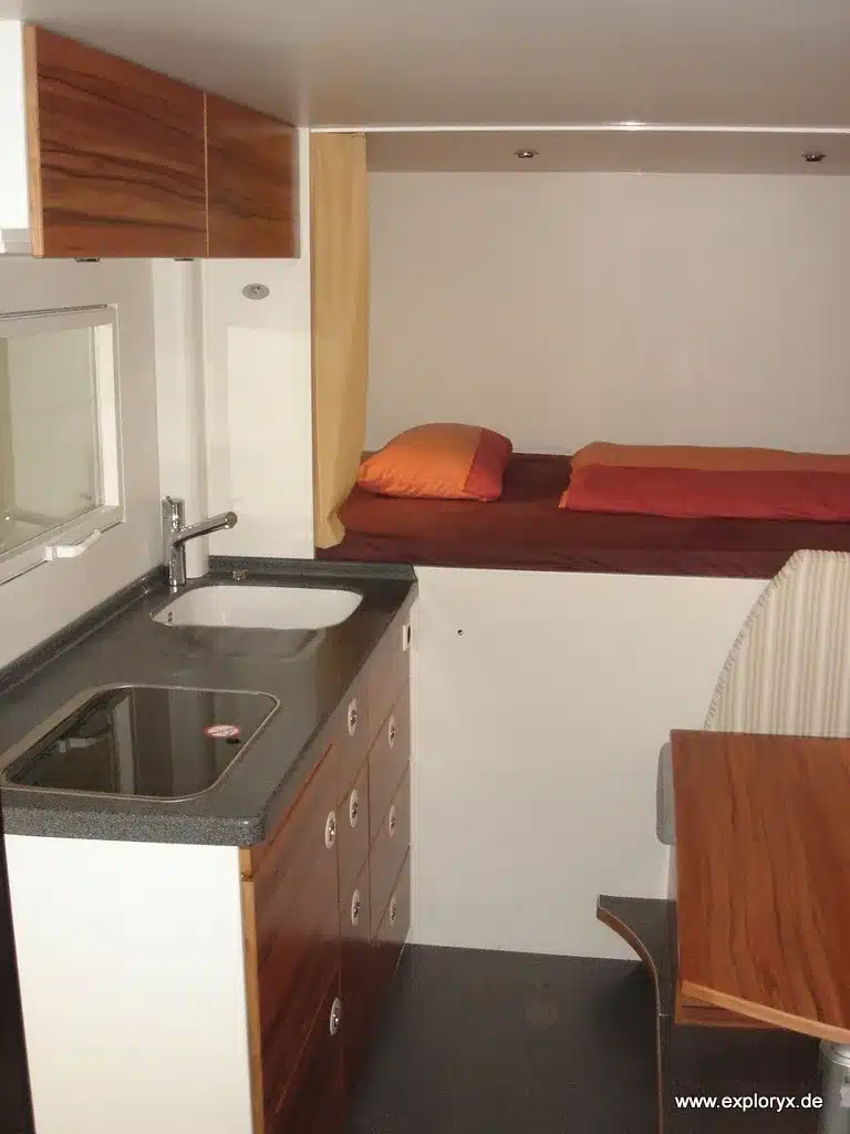 Innenansicht eines Expeditionsmobils vom Typ Exploryx Nyala I auf Mercedes Atego mit Küche, Sitzgruppe und Bett