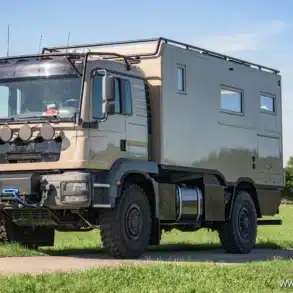 Exploryx Nyala MAN II Expeditionsfahrzeug auf MAN TGM 18.340, parkend auf Wiese, Seitenansicht mit LKW-Fahrerhaus und Wohnkabine