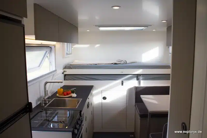 Blick in den Innenraum eines Exploryx Nyala MAN Expeditionsmobils mit Küche, Sitzgruppe und Bett