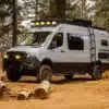 Offroad-ausgebauter Mercedes Sprinter 170 High Roof, Modell Güero, mit Dachträger, Leiter und Zusatzscheinwerfer im Wald
