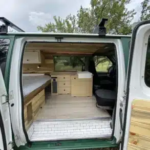 Innenansicht der Green Machine 6AK25 mit Bett, Stauraum und Küchenmodul