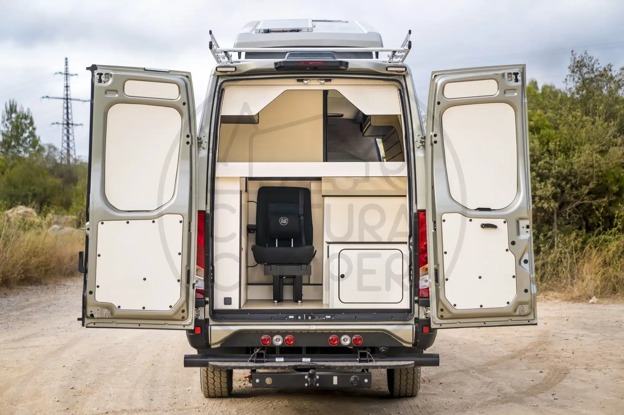 Geöffnete Hecktüren eines Iveco Daily 4x4 Campers mit Blick auf den Innenraum und Sitzbank