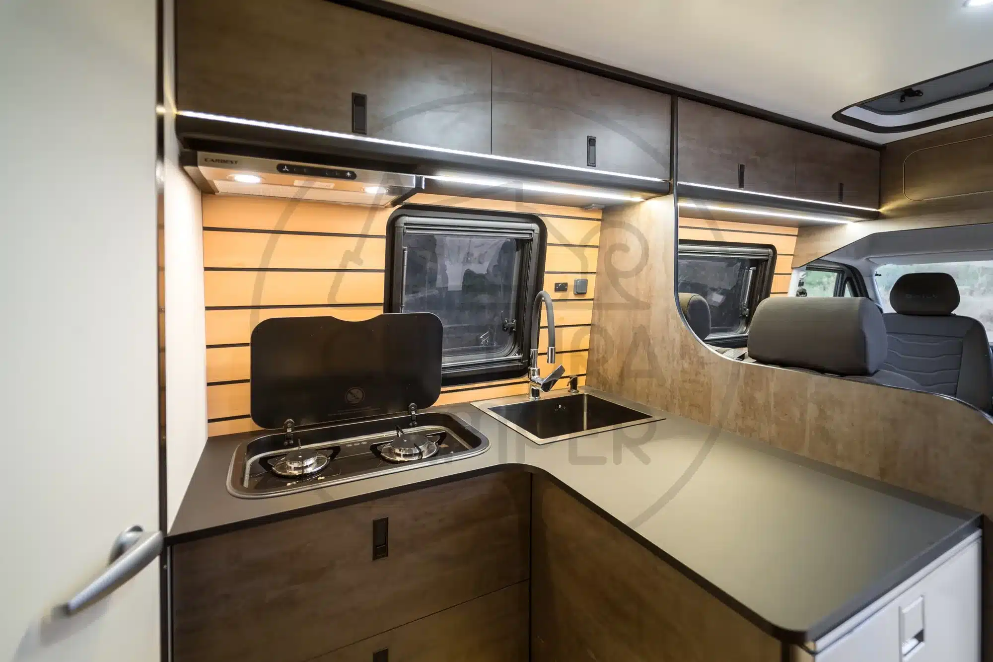 Küche im Innenraum eines Iveco Daily 4x4 Expeditionscampers mit Gasherd, Spüle und Oberschränken