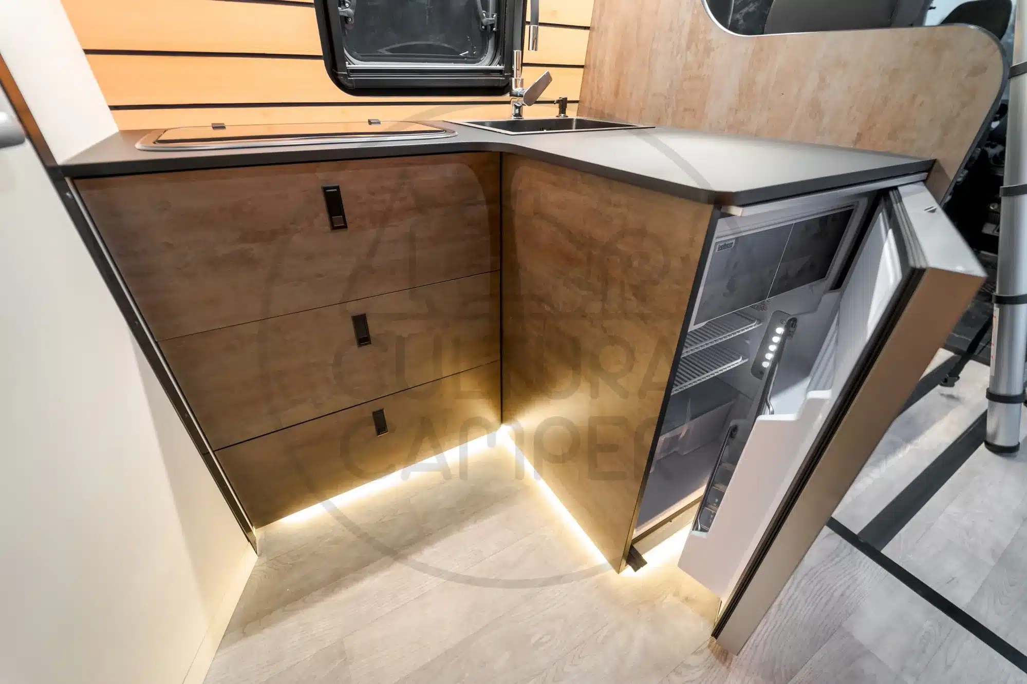 Küchenzeile mit Holzdekor, Kühlschrank und Spüle im Expeditionscamper auf Iveco Daily 4x4 Basis