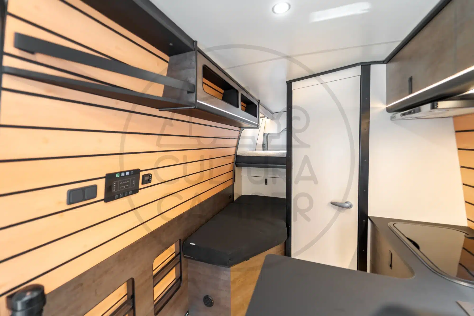 Innenansicht des individuell ausgebauten Iveco Daily 4x4 Campers mit Schlafgelegenheit und Stauraum