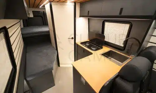 Innenansicht eines ausgebauten Iveco Daily 4x4 mit Küchenzeile, Sitzplätzen und Schlafbereich