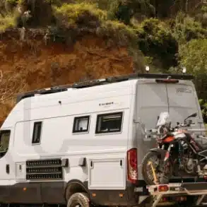 Seitenansicht eines Iveco Daily 4x4 L4H3 Expeditionsmobils mit Motorradträger vor Naturkulisse