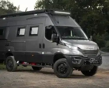 Seitenansicht eines Iveco Daily 4x4 L4H3 Campers mit Expeditionsausbau, Geländereifen und Montagen im Gelände.