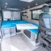 Innenraum eines Ram Promaster Low Roof mit Querbett, Sitzgruppe und Stauraum
