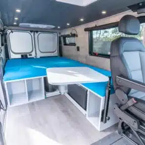 Innenraum eines Ram Promaster Low Roof mit Querbett, Sitzgruppe und Stauraum