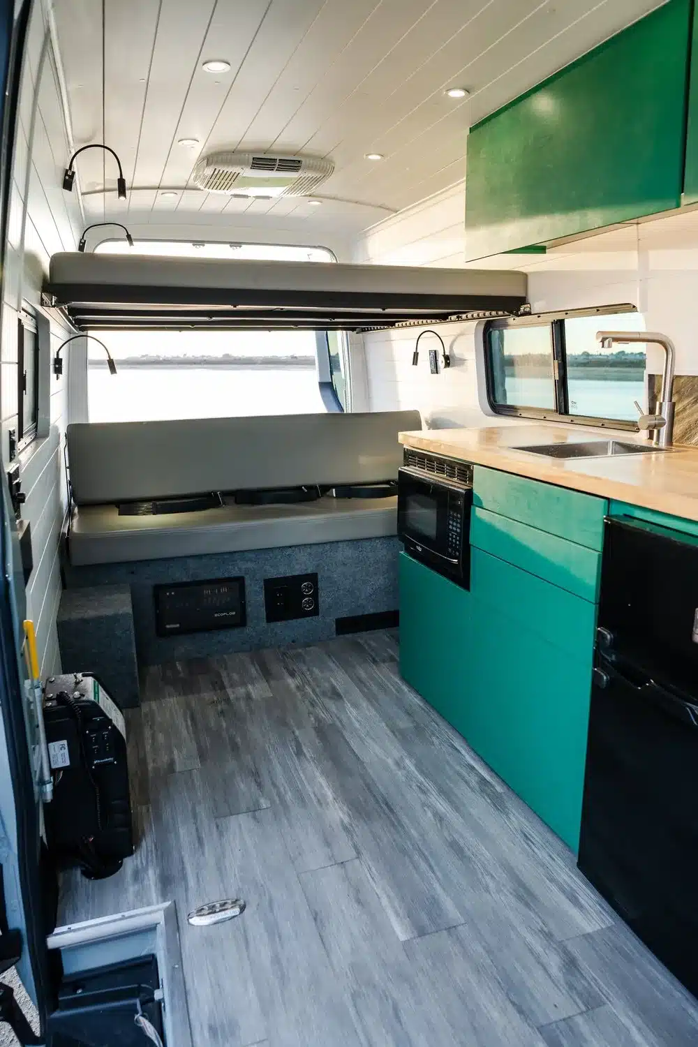 Barrierearmer Innenausbau eines Maverick-Sprinter-Campers mit Sitzbank, Absenk-Bett, Küchenzeile und modernen Möbeln.