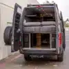 Heckansicht eines Offroad-Kastenwagens Mercedes Sprinter Fort Knox mit offenem Bett und Stauraum.