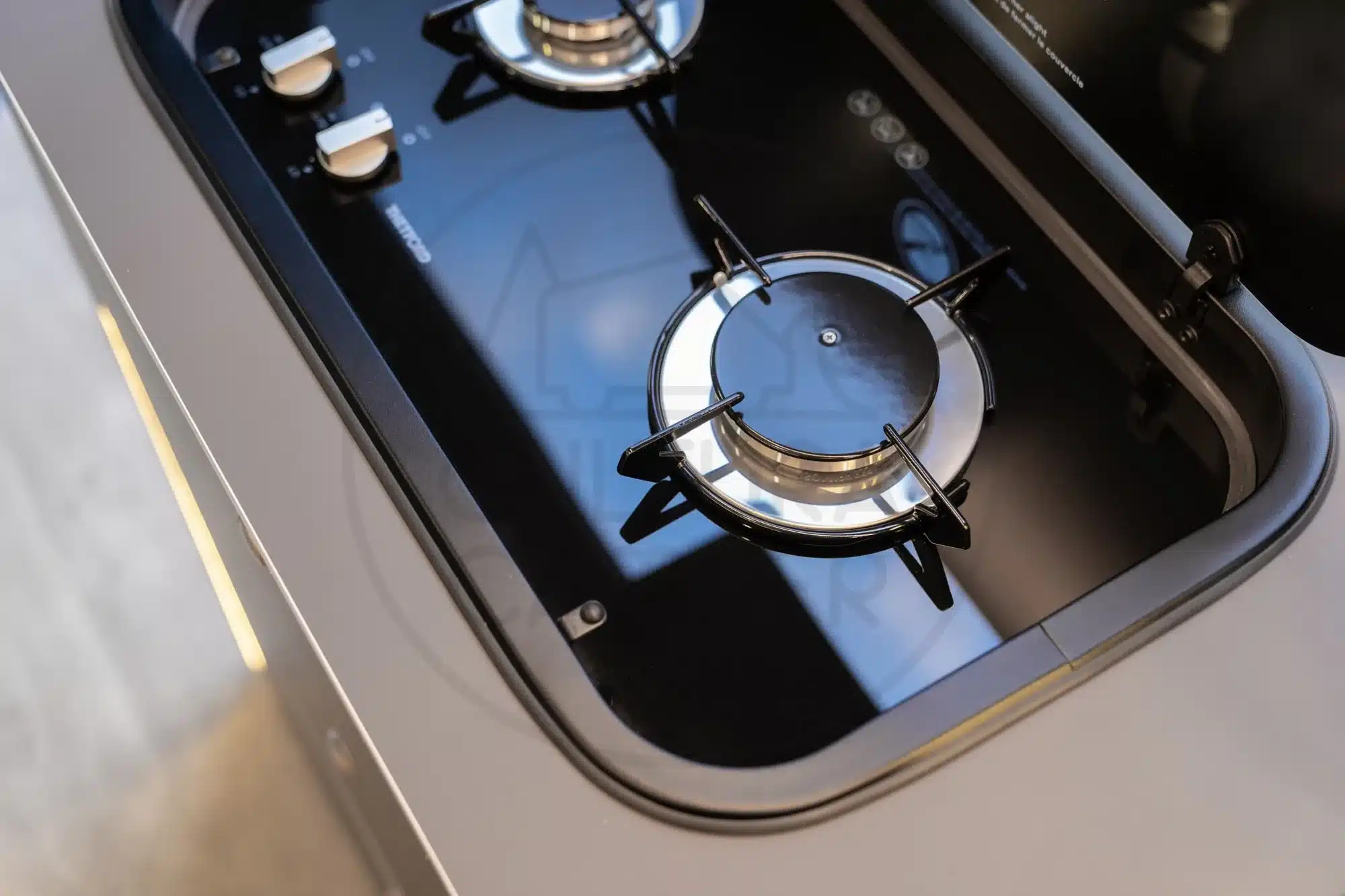 Detailaufnahme eines zweiflammigen Gaskochers in einer Camper-Küche, eingebaut im Mercedes Sprinter L4-H2