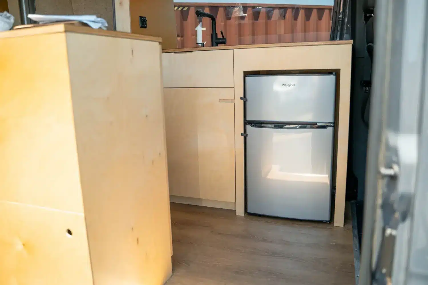 Küchenzeile aus Birkenholz mit eingebautem Kühlschrank im Moose Camper-Ausbau
