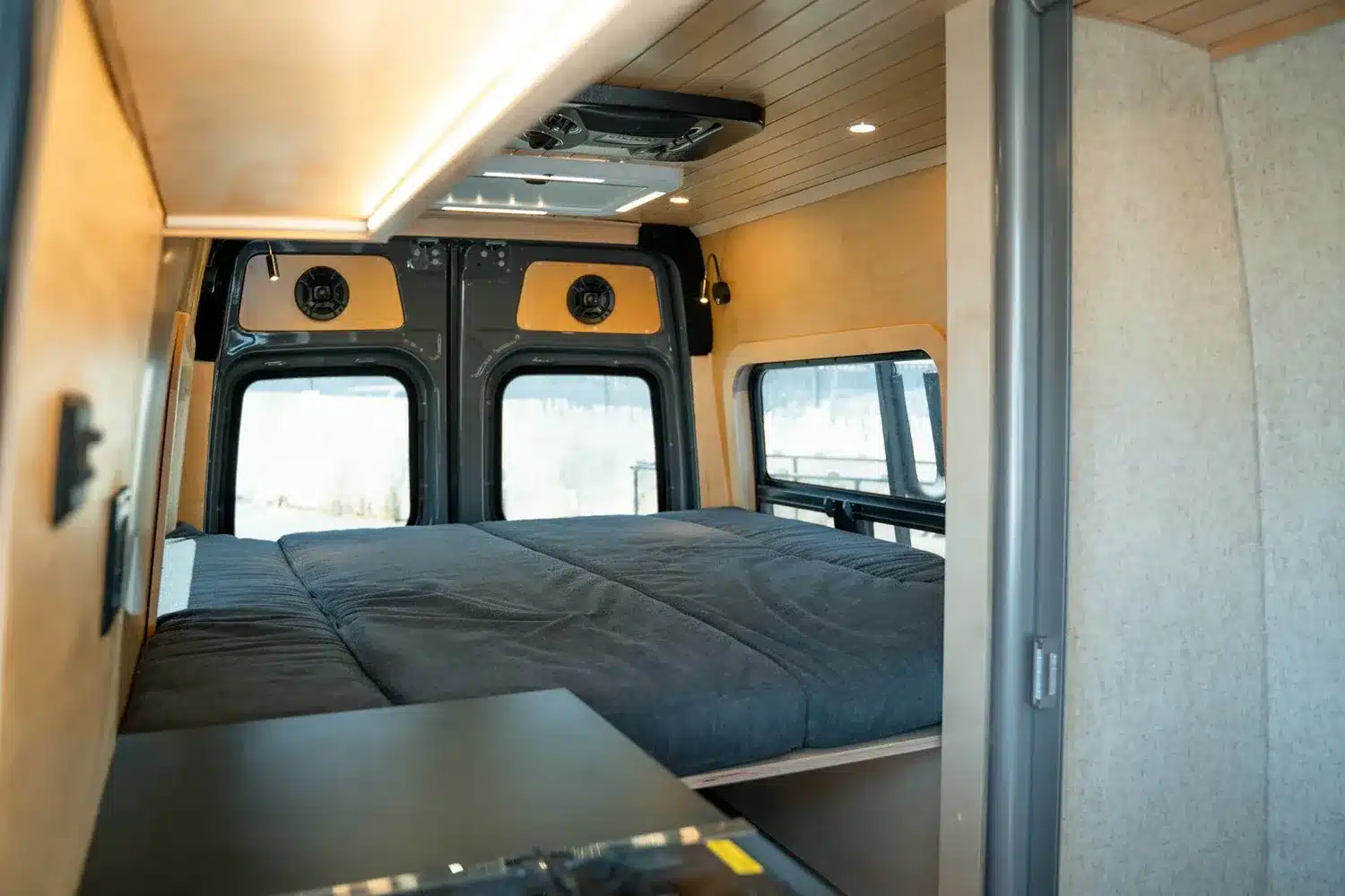 Innenansicht des Moose-Campervans mit großem Bett, Holzverkleidung und modernen Details