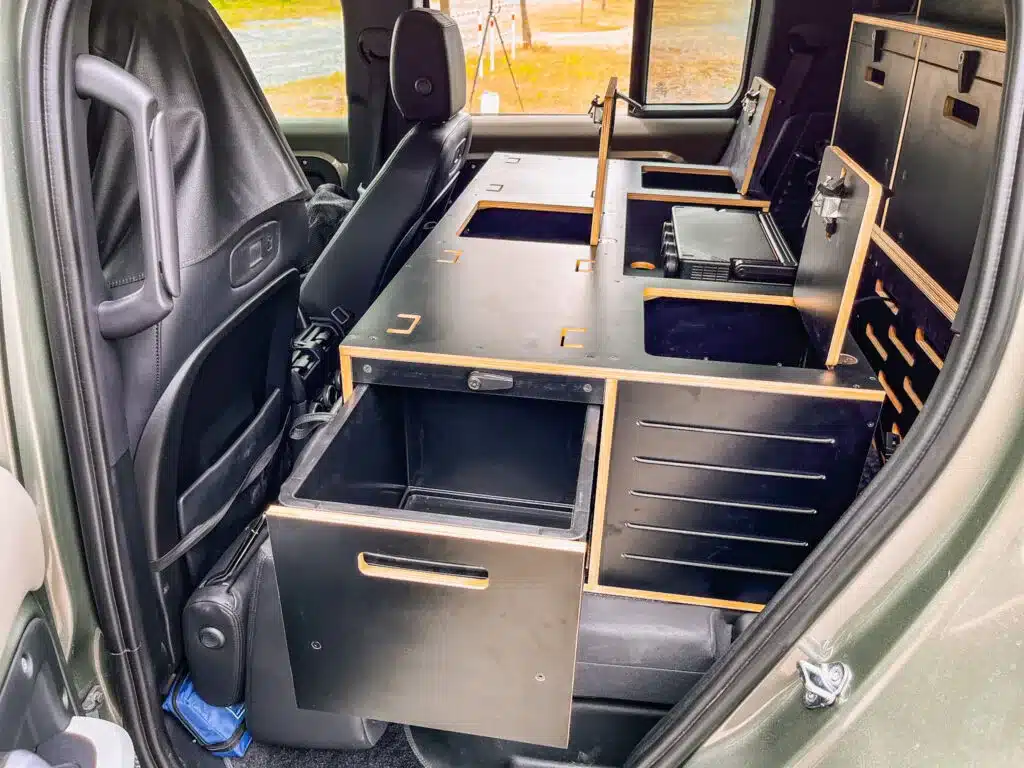 Modulares Camping-Box-System mit Schubladen und Stauraum im Heck eines Land Rover Defender