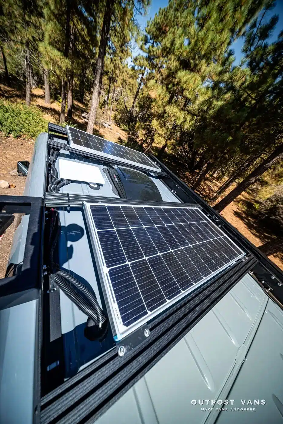 Solarmodule und Starlink-Antenne auf dem Dach eines Outpost Vans CRAG im Wald
