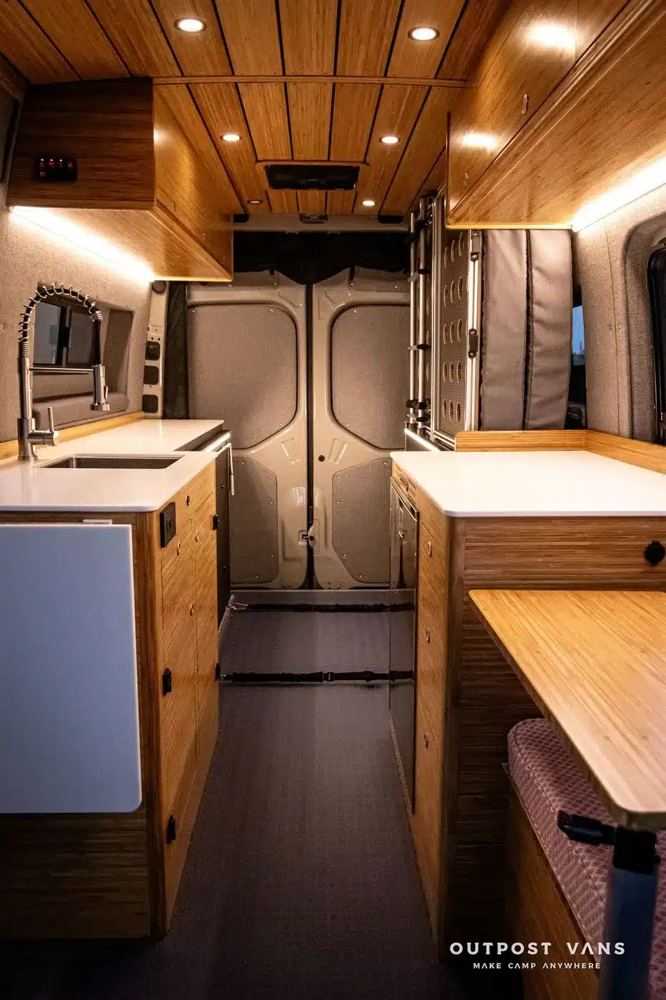 Innenraum des DUNE Campervans auf Mercedes Sprinter Basis mit Bambusmöbeln, Küchenzeile und Sitzbereich