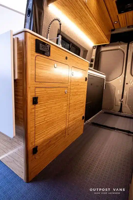 Bambus-Küchenzeile mit moderner Armatur und Stauraum im Campervan.