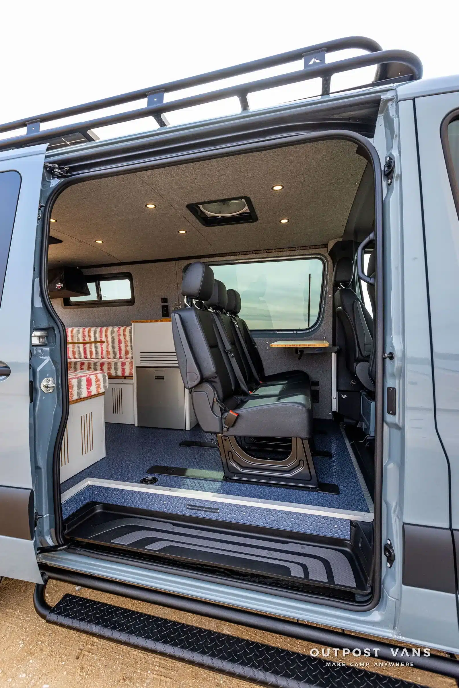 Innenraum eines Outpost Vans Jasper Campervans mit Sitzbank, Dinette, niedrigem Dach und Dachträger.