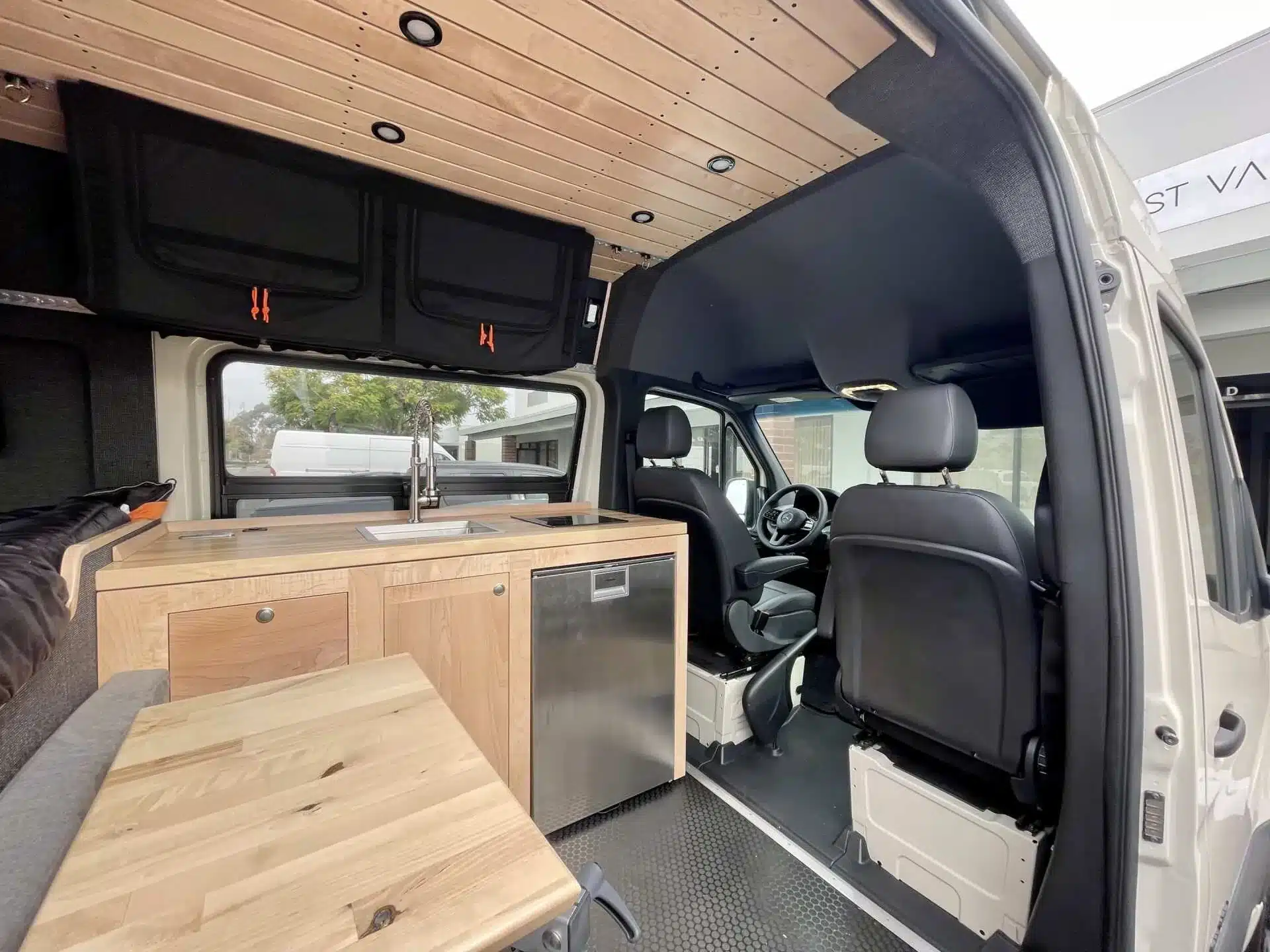 Innenansicht des Outpost Vans OPV-04 mit Küchenzeile, Stauraum und Fahrerbereich