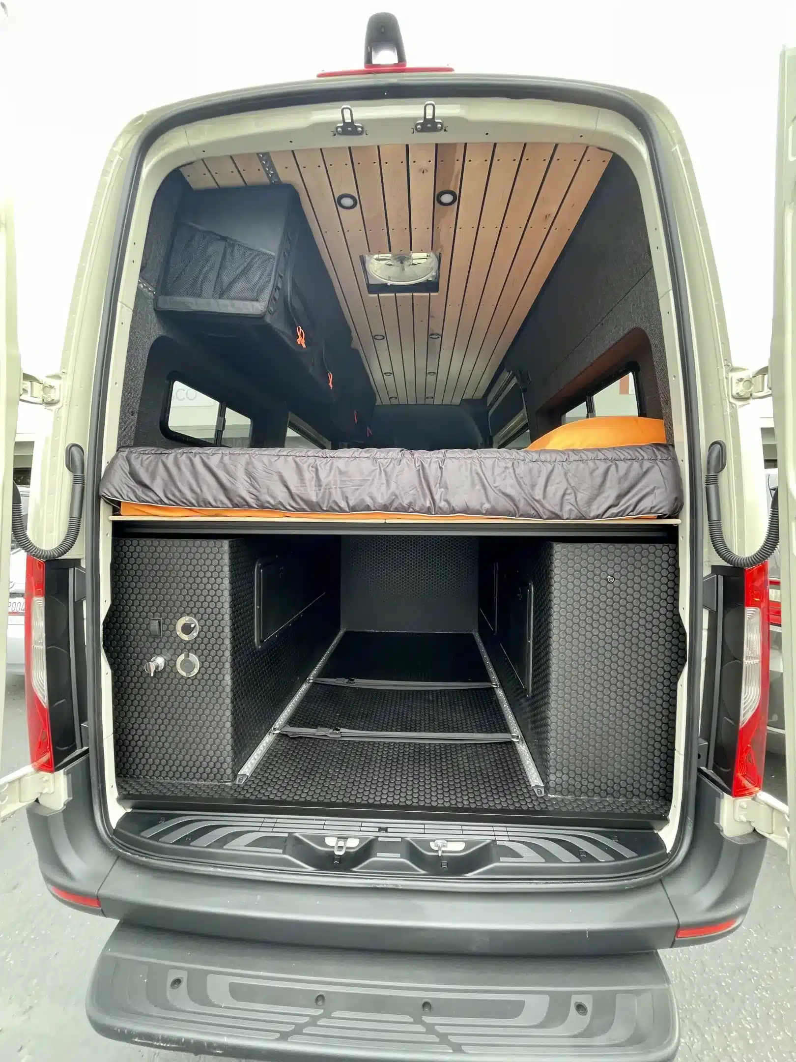 Offenes Heck eines Outpost Vans OPV-04 mit Bett und großem Stauraum
