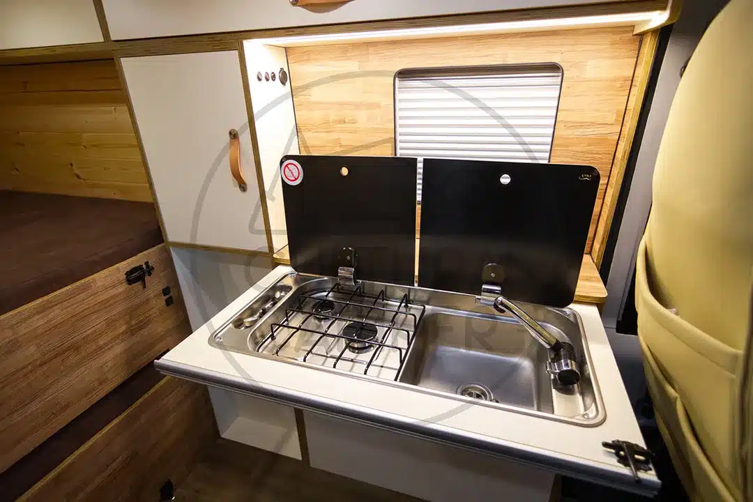 Küchenzeile mit Gaskocher und Spüle im Innenraum eines Peugeot Boxer L1H1 Campervans