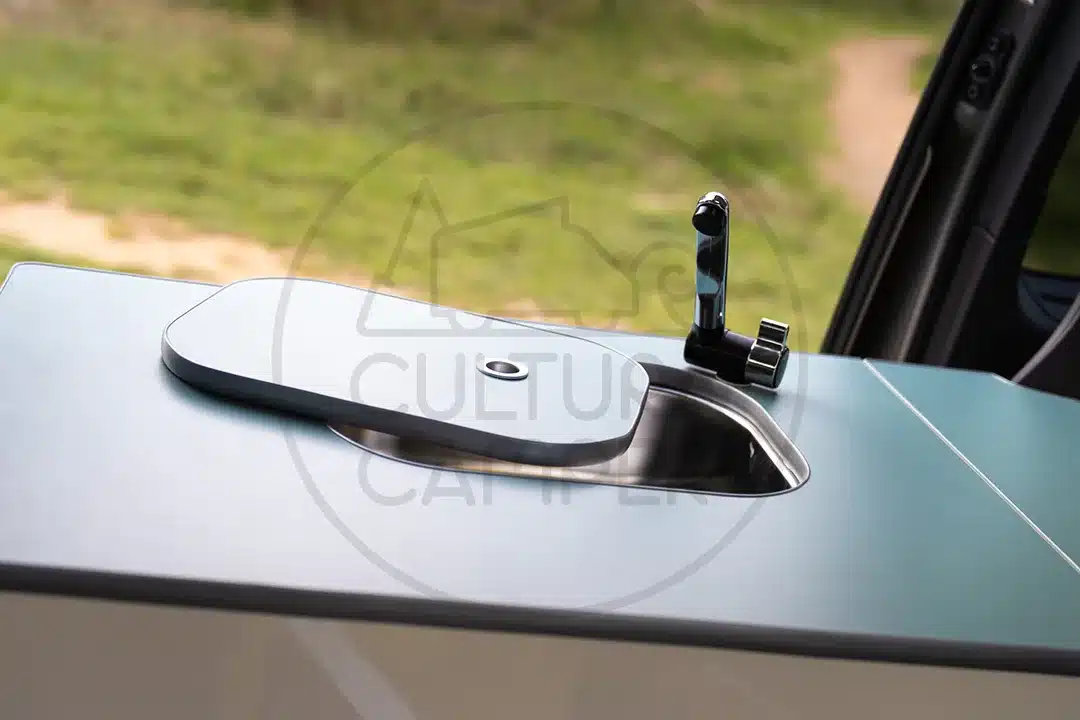 Camper-Spüle mit Wasserhahn und geschlossener Abdeckung im Peugeot Traveller Ausbau.