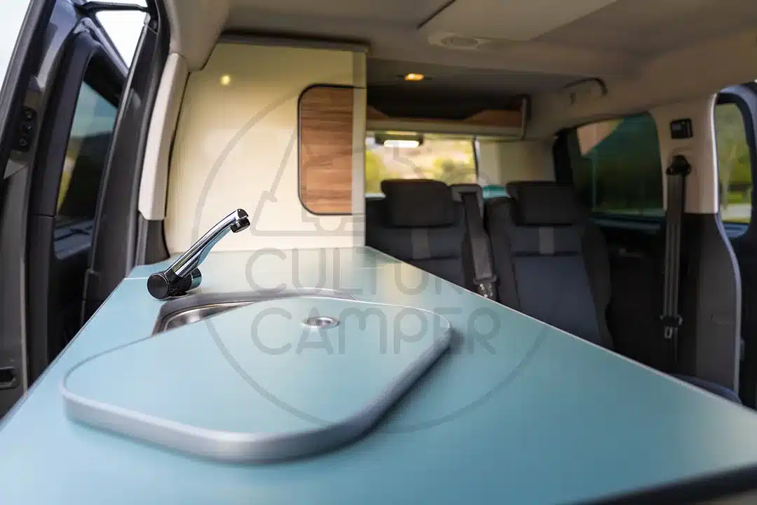Küchenbereich mit Spüle und Sitzgruppe im Peugeot Traveller Campervan