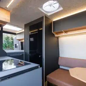 Innenraum eines Mercedes-Benz Sprinter 4x4 Campervans Project Hispaniola mit Küche, Sitzbank und Oberschränken.