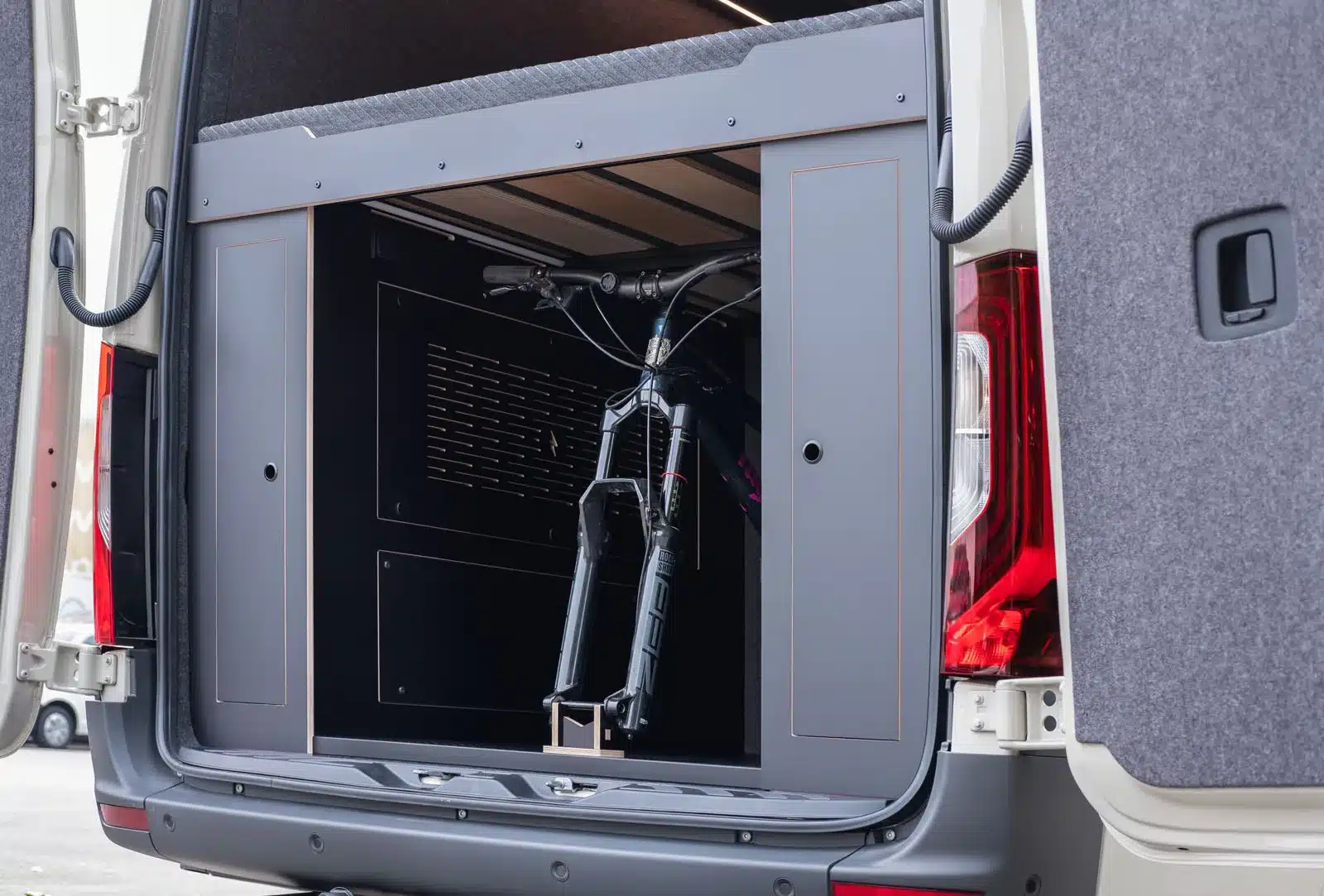 Heckansicht eines Mercedes Sprinter Campers mit modernem Stauraum und Fahrrad im Inneren