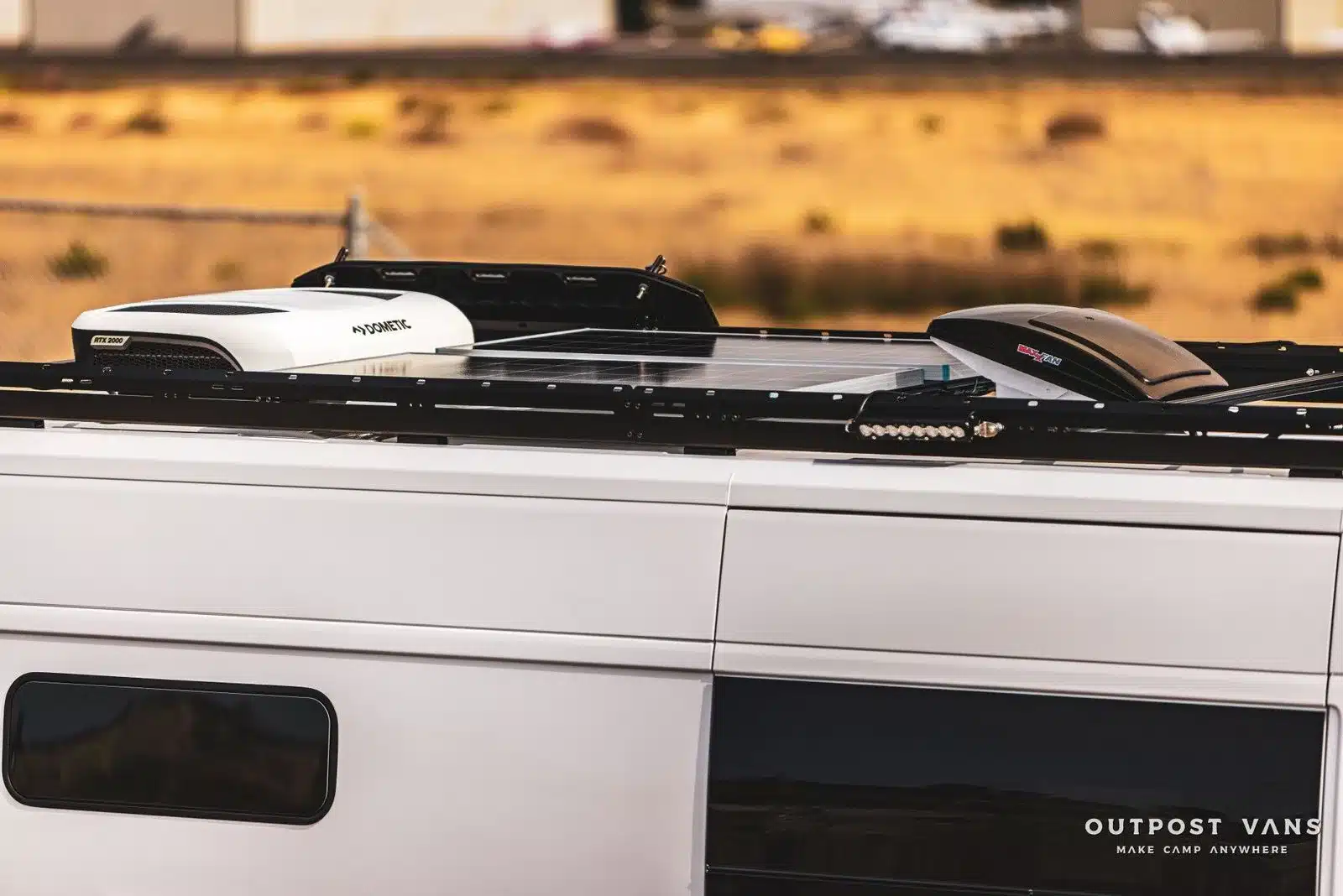 Solarmodule sowie Dachklimaanlage und Lüfter auf dem Dach eines ausgebauten Ram Promaster Altitude Campervans.