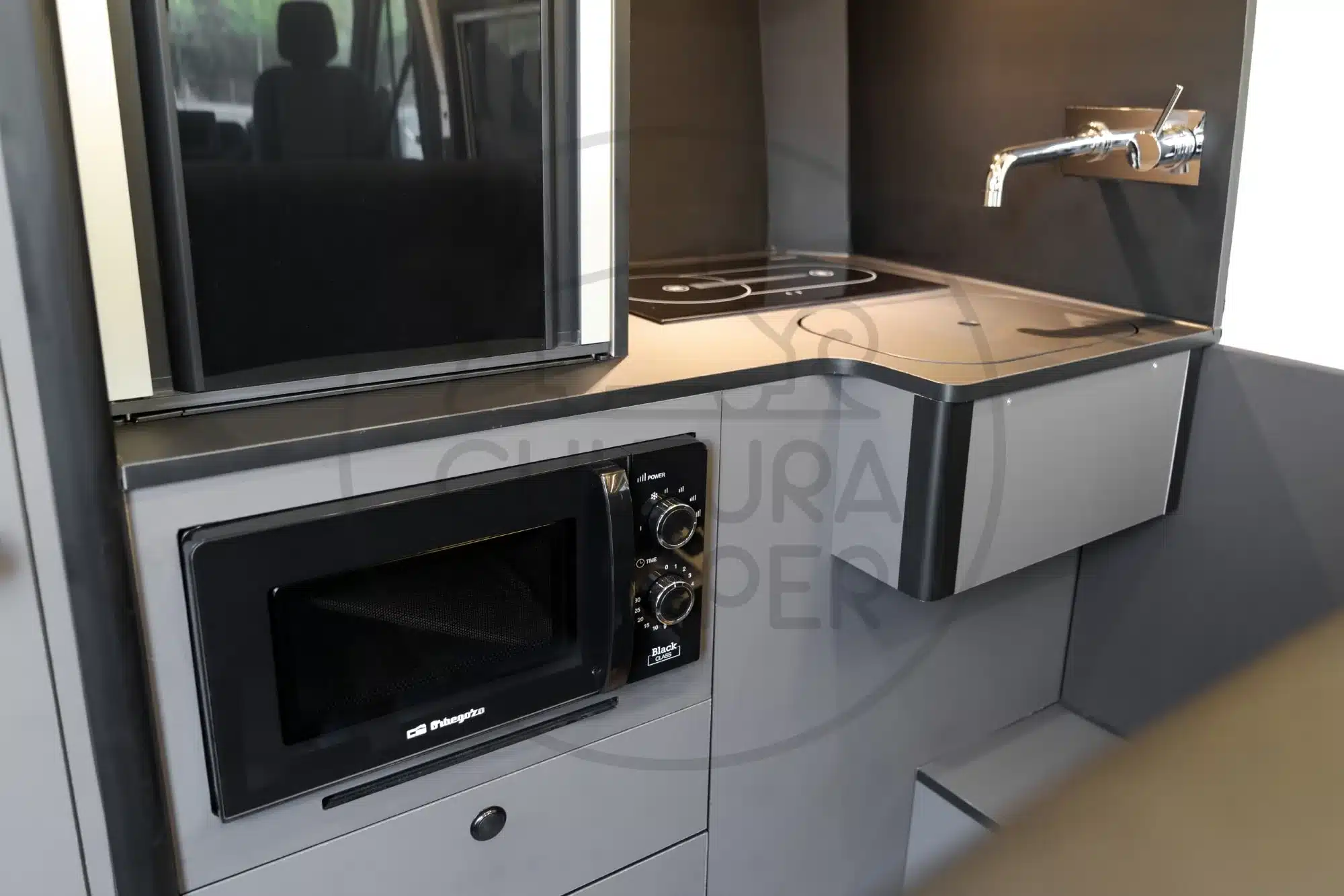 Innenansicht der Küchenzeile mit Mikrowelle, Spüle und Dieselkocher im Renault Master Camper