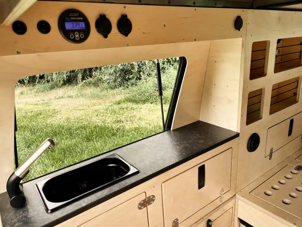Küchenzeile mit Spülbecken und Holzverkleidung im Toyota Land Cruiser Camper