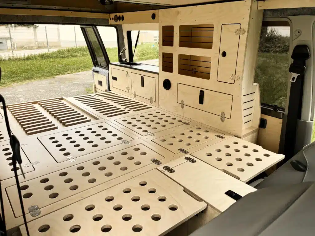 Innenansicht eines ausgebauten Toyota Land Cruiser 76 mit modularen Holzplatten als Bett und Stauraum