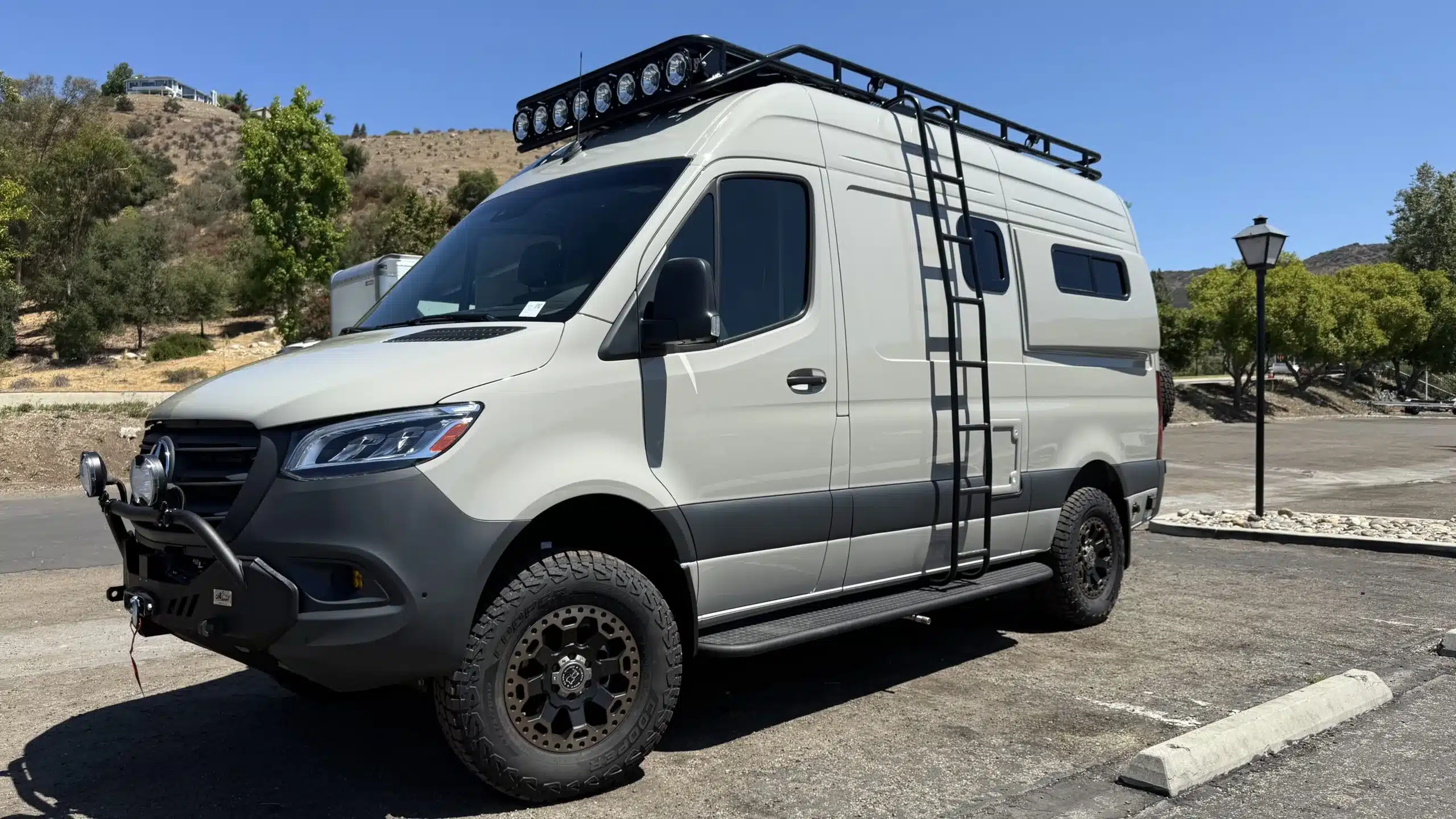 Der Trail-Hob Adventure-Van auf Sprinter 144 Allrad-Basis mit robustem Außenausbau, Leiter und Dachträger, ideal für Reisen mit Hund.