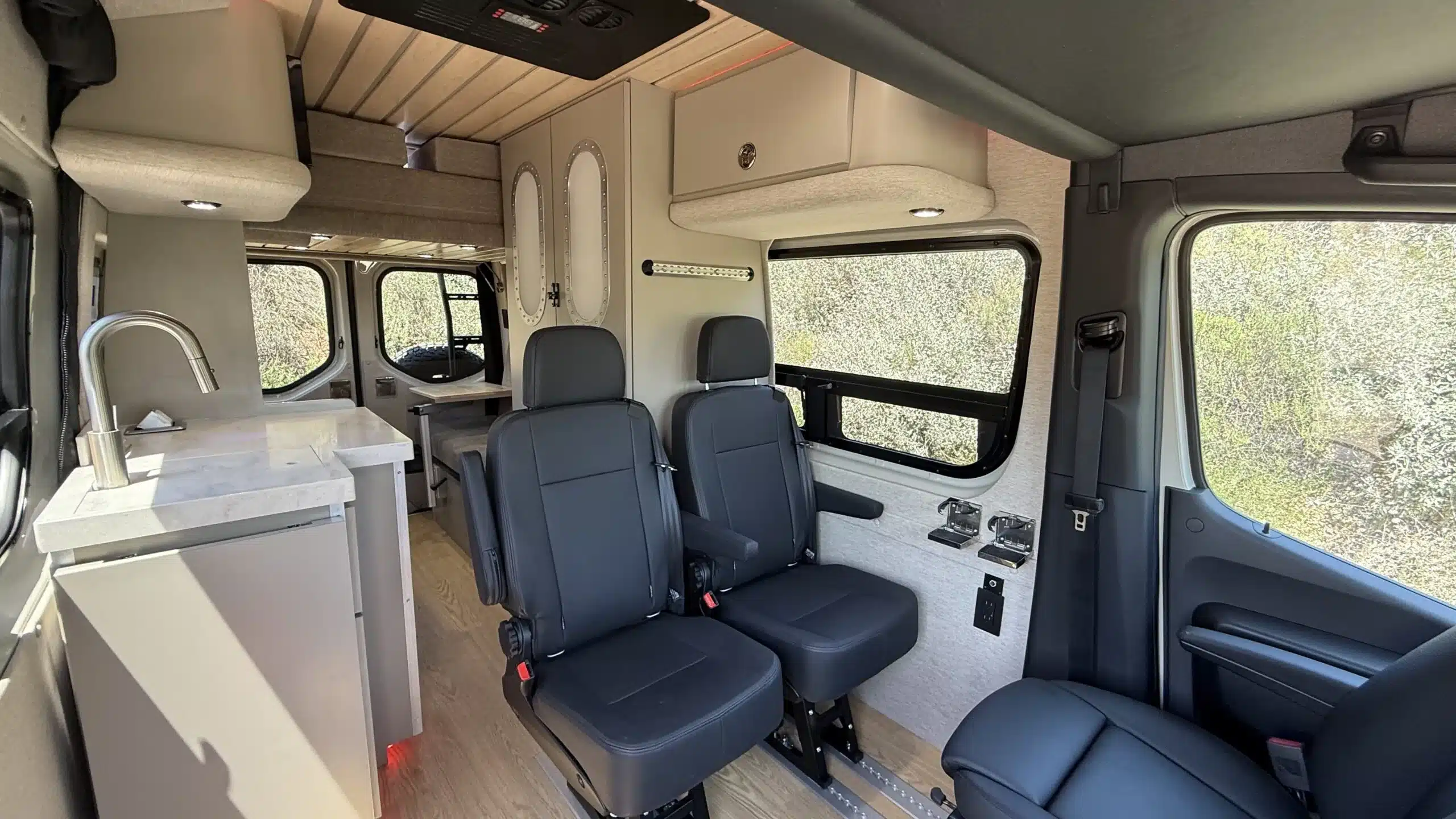 Innenraum eines Trail Hob Campervans mit flexiblen Sitzen, Küchenzeile und Stauraum auf Basis eines Mercedes Sprinter